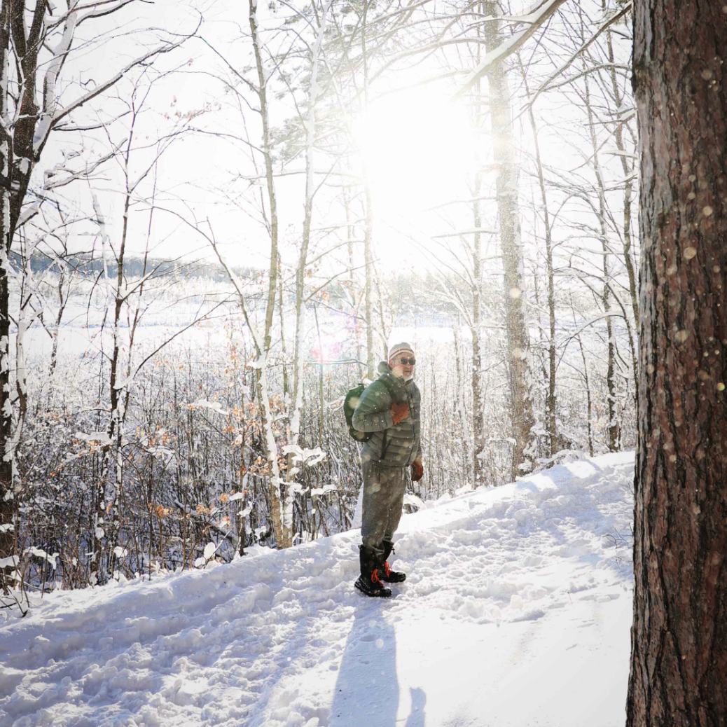Paul, the founder of Element Three, hiking in the woods on a winter day.